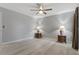 Bedroom with ceiling fan, neutral walls, light wood-look floors, and side tables with lamps at 710 Treasure Boat Way, Sarasota, FL 34242