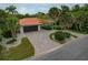 Stunning single-story home with a tile roof, meticulously landscaped grounds, and a long, winding brick driveway at 710 Treasure Boat Way, Sarasota, FL 34242