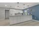 Open-concept kitchen with a large island, white cabinets, updated appliances, and light wood floors at 710 Treasure Boat Way, Sarasota, FL 34242