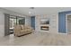 Cozy living room with wood floors, a modern electric fireplace, and sliding doors to the screened lanai at 710 Treasure Boat Way, Sarasota, FL 34242