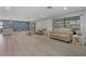 Spacious living area with sleek wood floors, neutral sofas, and views of the pool at 710 Treasure Boat Way, Sarasota, FL 34242