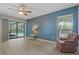 Bright living room features a ceiling fan, neutral paint, and sliding doors to the pool at 710 Treasure Boat Way, Sarasota, FL 34242