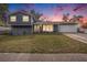 Charming two-story home featuring a well-maintained lawn and inviting facade against a colorful twilight sky at 8019 Capwood Ave, Temple Terrace, FL 33637