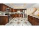 Spacious kitchen with stainless steel appliances, dark wood cabinetry, and designer tile floor at 8019 Capwood Ave, Temple Terrace, FL 33637