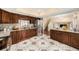 Lovely kitchen with breakfast bar, granite countertops, designer tile floors, and staircase access at 8019 Capwood Ave, Temple Terrace, FL 33637