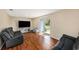 Bright living room with wood floors, sliding glass door, and dark-colored sofas at 8019 Capwood Ave, Temple Terrace, FL 33637