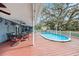 Covered deck with outdoor dining, overlooking the private pool and lush backyard at 8019 Capwood Ave, Temple Terrace, FL 33637