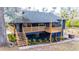 Inviting raised home featuring a wooden deck, staircase, and landscaped yard at 8204 Stoner Rd, Riverview, FL 33569