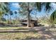 Charming raised bungalow with wraparound deck surrounded by lush greenery at 8204 Stoner Rd, Riverview, FL 33569