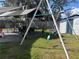 A backyard features a patio dining area under a canopy and a swing set next to a storage shed at 8706 N Boulevard, Tampa, FL 33604