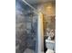 Updated shower with gray stone-like tile extending to the ceiling, a rainfall shower head, and sleek fixtures at 8706 N Boulevard, Tampa, FL 33604
