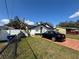 Features of a well-kept, single-story home with a lush green lawn and black car at 8706 N Boulevard, Tampa, FL 33604