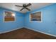 A simple blue bedroom, with tiled flooring and a ceiling fan at 9435 Ottawa St, New Port Richey, FL 34654