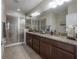 The bathroom has a double vanity with granite countertops and a glass-enclosed shower at 1002 Vineyard Ln, Oldsmar, FL 34677