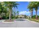 Gated community entrance with lush landscaping, palm trees, and a secure access point at 1002 Vineyard Ln, Oldsmar, FL 34677