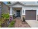 Charming front entrance with a welcoming porch, brick pathway, and beautifully landscaped garden at 1002 Vineyard Ln, Oldsmar, FL 34677