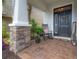 Close-up of the inviting front porch with brick flooring, rocking chair, and charming decor at 1002 Vineyard Ln, Oldsmar, FL 34677