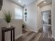 Well-lit hallway with wood floors, decorative wall decor, and an open doorway at 1002 Vineyard Ln, Oldsmar, FL 34677