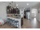 View of the modern kitchen featuring dark cabinets, granite countertops, stainless steel appliances, and pendant lighting at 1002 Vineyard Ln, Oldsmar, FL 34677