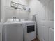 Laundry room equipped with a modern washer, dryer, and storage shelves at 1002 Vineyard Ln, Oldsmar, FL 34677