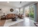 Living room featuring a leather sofa, accent chair, and access to the patio through a sliding glass door at 1002 Vineyard Ln, Oldsmar, FL 34677