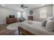 This bedroom features a ceiling fan, wood floors, and large windows at 1002 Vineyard Ln, Oldsmar, FL 34677