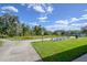 Relaxing community green space with a concrete walking path, offering benches and lush greenery at 1002 Vineyard Ln, Oldsmar, FL 34677