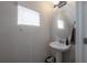 This stylish powder room features a pedestal sink, a round mirror, and a window at 1002 Vineyard Ln, Oldsmar, FL 34677