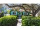 Charming green home with lush landscaping, teal shutters, and inviting walkway at 114 27Th N Ave, St Petersburg, FL 33704