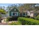 Charming green home with turquoise shutters, complemented by lush landscaping and a stone pathway at 114 27Th N Ave, St Petersburg, FL 33704