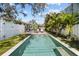 Sparkling pool surrounded by palm trees, lush greenery, and a white fence at 114 27Th N Ave, St Petersburg, FL 33704