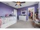 Charming purple bedroom with a bed, dresser, walk-in closet, and carpet flooring at 11938 Bahia Valley Dr, Riverview, FL 33579