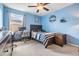 Serene bedroom with blue walls, comfortable bed, and a well-lit desk area at 11938 Bahia Valley Dr, Riverview, FL 33579