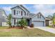 Beautiful two-story blue home with a well-manicured lawn, mature landscaping and a two-car garage at 11938 Bahia Valley Dr, Riverview, FL 33579