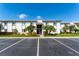 Exterior view of condo building with parking, tropical trees, and well-maintained landscaping at 129 W Cypress Ct, Oldsmar, FL 34677