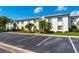 Exterior view of condo building with parking, tropical trees, and well-maintained landscaping at 129 W Cypress Ct, Oldsmar, FL 34677