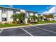 Exterior view of condo building with tropical trees, parking, and well-maintained landscaping at 129 W Cypress Ct, Oldsmar, FL 34677