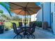 Relaxing outdoor patio with shade umbrella, dining set, and garden view at 129 W Cypress Ct, Oldsmar, FL 34677