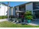 The condo's inviting patio with umbrella, table, chairs, and lush landscaping is great for relaxing at 129 W Cypress Ct, Oldsmar, FL 34677