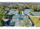 Aerial view of numerous tennis courts, featuring shaded benches and well-maintained landscaping, adding to the community's active lifestyle at 129 W Cypress Ct, Oldsmar, FL 34677