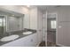 Bathroom featuring a dual vanity with gray countertops and an adjacent bedroom at 13022 Wellspring Dr, Lithia, FL 33547