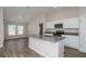 Modern kitchen featuring white cabinets, stainless steel appliances, gray counters and island with sink at 13022 Wellspring Dr, Lithia, FL 33547