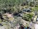 Aerial view of property highlights lush trees, outbuildings and the location of the property's creek at 13215 Seminole Trl, Wimauma, FL 33598