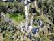 An aerial view showcases a sprawling lot with various outbuildings and tree coverage at 13215 Seminole Trl, Wimauma, FL 33598