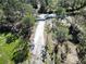 Long driveway with gate amidst lush trees creates a private entrance to the property at 13215 Seminole Trl, Wimauma, FL 33598