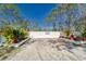 Gated driveway entrance with lush plants and a well maintained fence at 13215 Seminole Trl, Wimauma, FL 33598