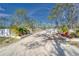 Driveway with white fence entrance and beautiful landscaping at 13215 Seminole Trl, Wimauma, FL 33598