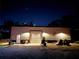 Metal garage with roll up door, illuminated by exterior lights at night at 13215 Seminole Trl, Wimauma, FL 33598