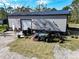 Large metal garage with roll up door, adjacent to manicured lawn at 13215 Seminole Trl, Wimauma, FL 33598