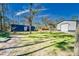 Well manicured lawn with metal garage, storage container, and shady trees at 13215 Seminole Trl, Wimauma, FL 33598